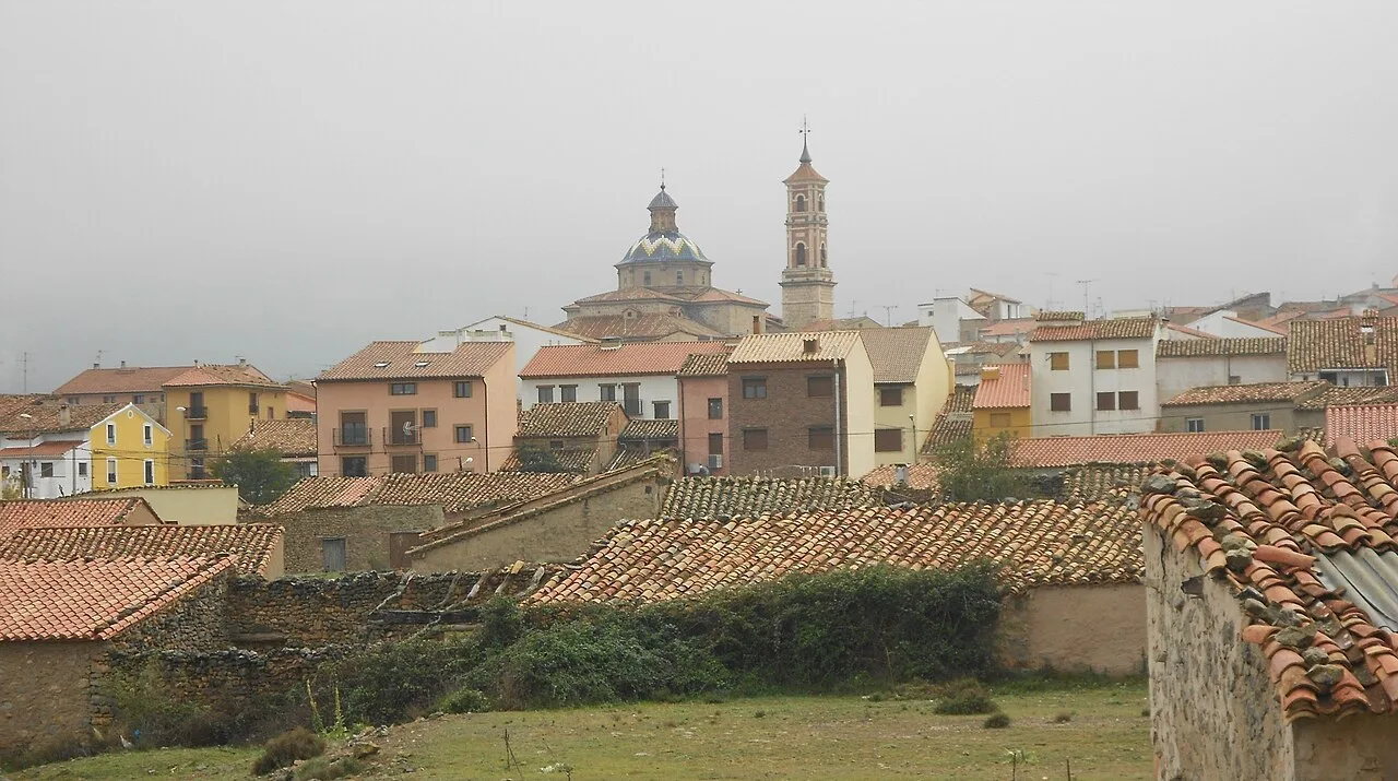 View of houses and a church in Sarrión, Teruel, on a cloudy day.